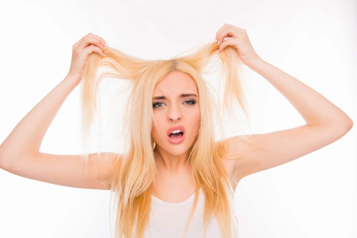 Sad pretty girl showing her damaged hair