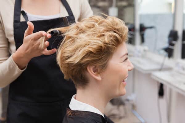 Hair salon client getting her hair styled at in a cute short haircut