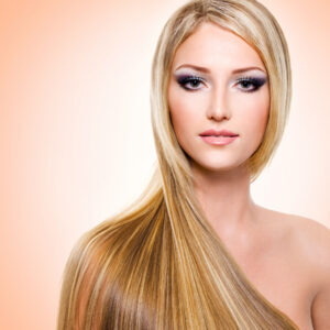 Beautiful woman with long straight blonde hair smooth after a keratin treatment
